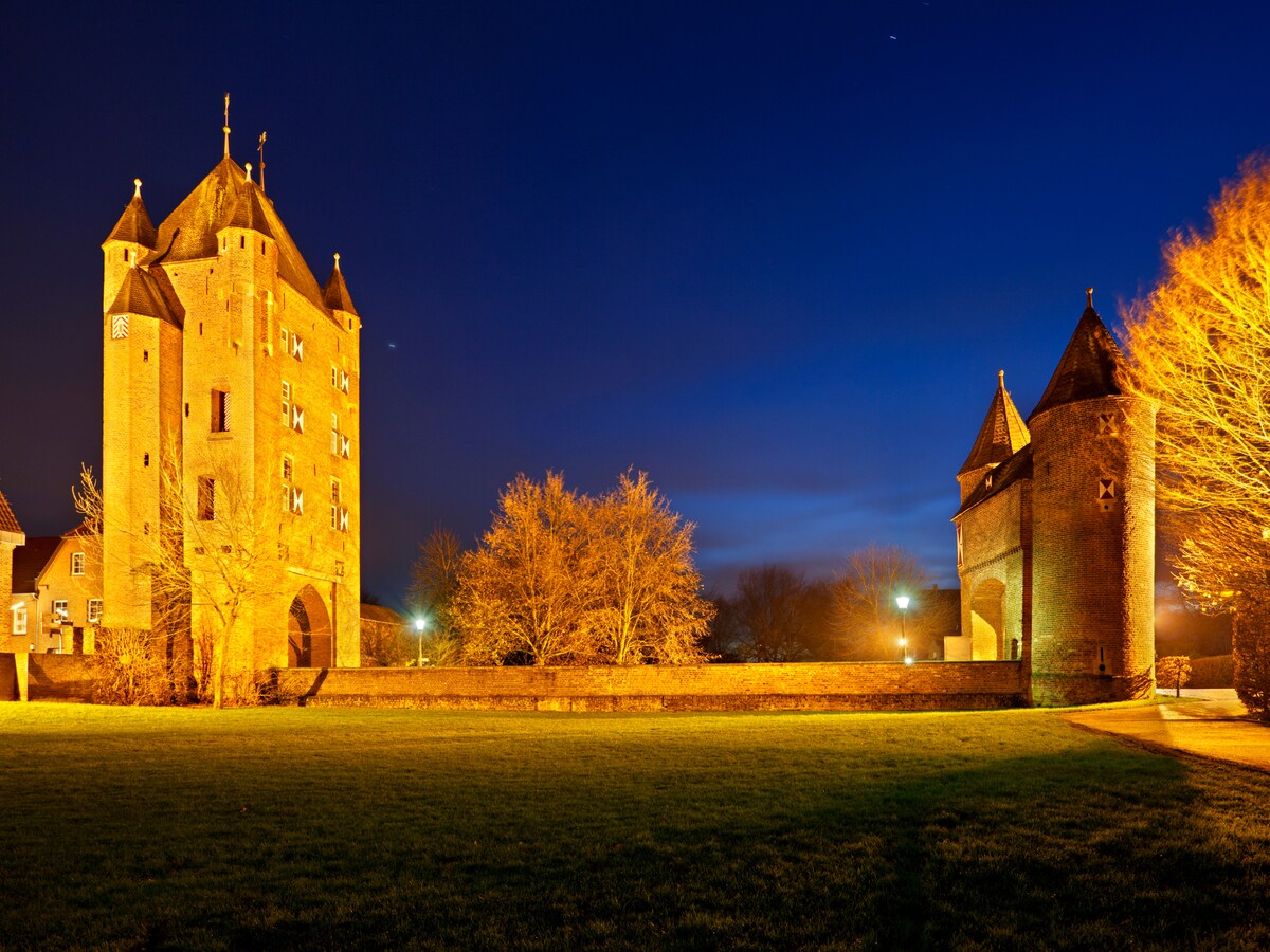 Beleuchtete historische Burg am Abend in der Region um Kranenburg